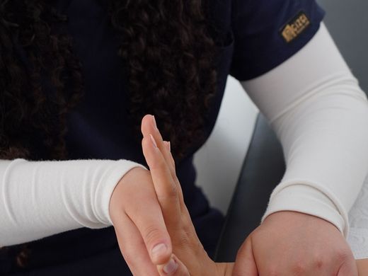 Nurse holding a patient's hand during a close follow-up visit.