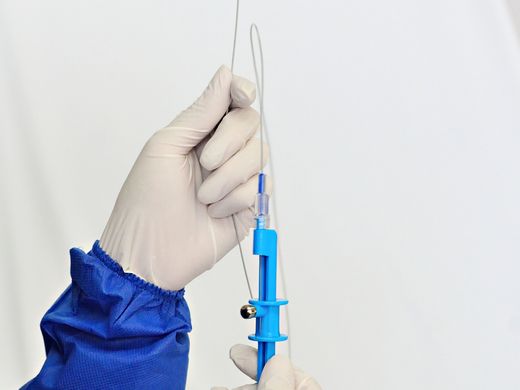 Gloved hands preparing sterile clinical supplies.
