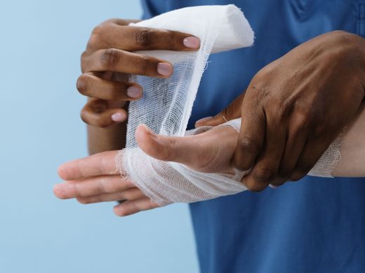Nurse applying a bandage to a patient's hand.